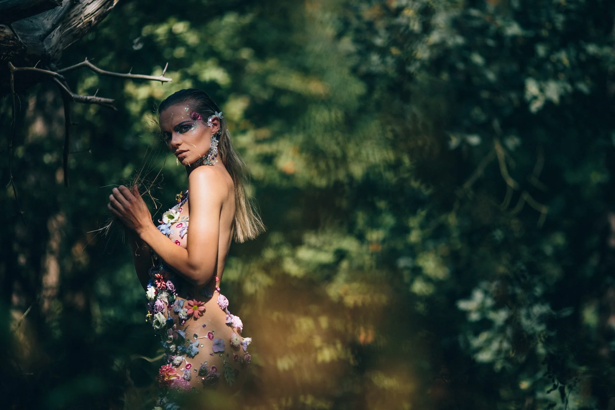 Vrouw met bloemversiering in bosomgeving