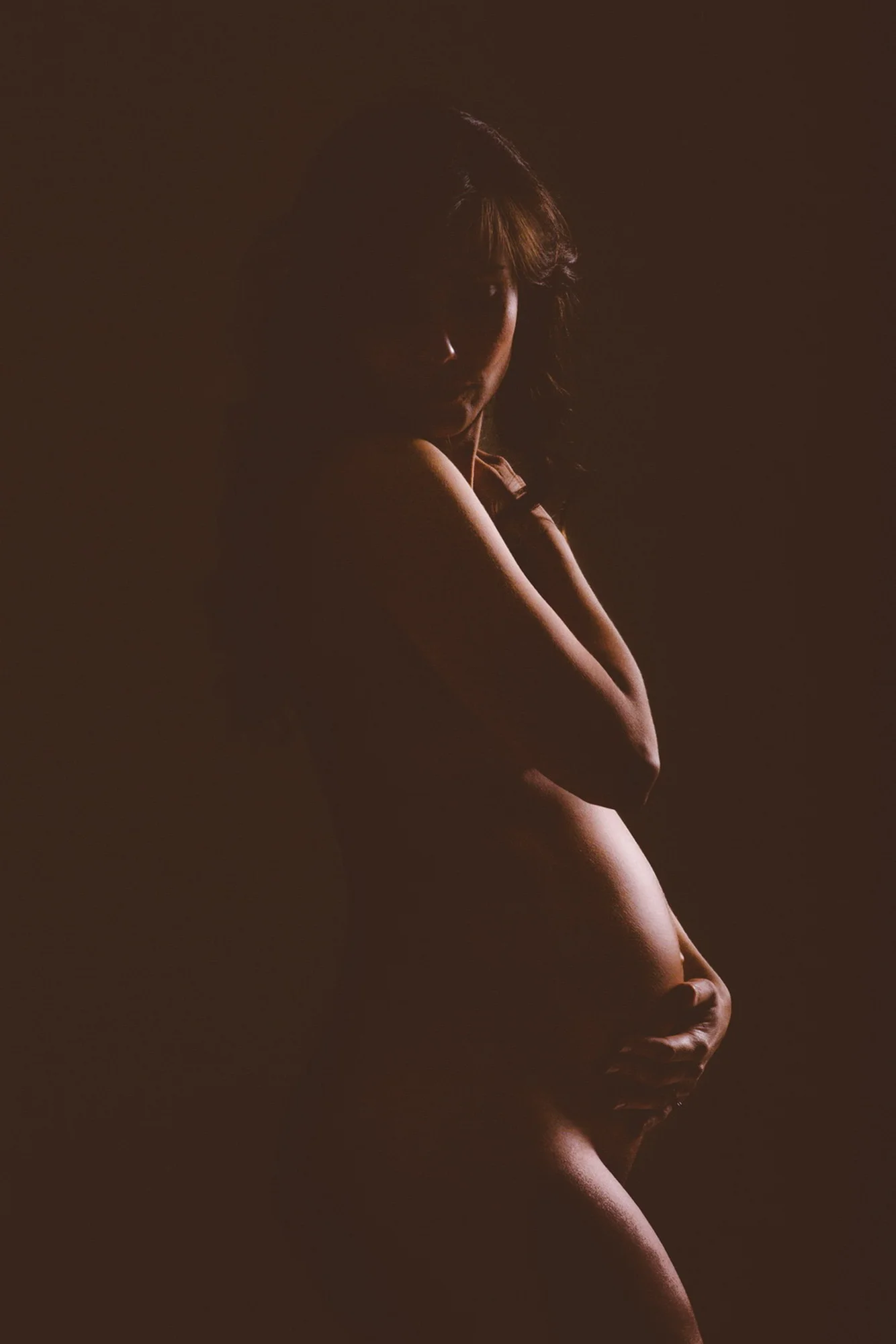Zwangere vrouw in profielfoto met kunstzinnige verlichting